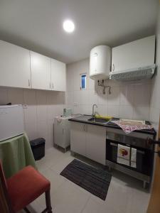 维塞乌Studios Rossio的小厨房配有白色橱柜和水槽
