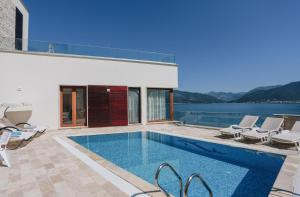 蒂瓦特Villa Semiramis的一个带椅子的游泳池以及一座房子