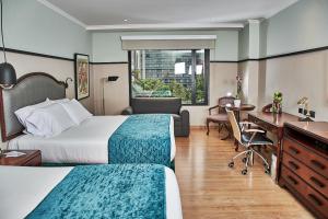 麦德林波普拉多广场酒店的酒店客房配有两张床和一张书桌
