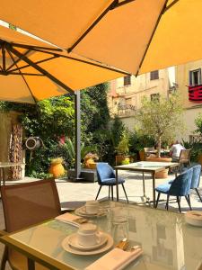 阿雅克修Hotel POZZO DI BORGO的庭院里配有桌椅和遮阳伞