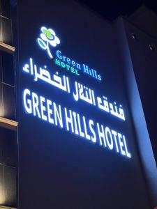 An Nimāşفندق التلال الخضراء的墙上绿色山丘酒店的标志