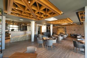 普里兹伦Hotel Castello的餐厅设有木制天花板和桌椅