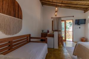 托兰克索Casa Luar Trancoso的一间卧室配有一张床,厨房配有桌子