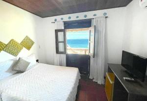 莫罗圣保罗Vista Bela Pousada的一间卧室设有一张床和一个海景窗户