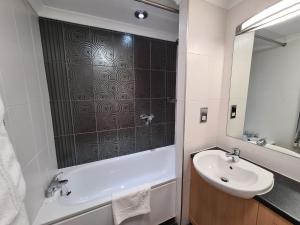 利物浦皇家酒店的一间带水槽、浴缸和镜子的浴室