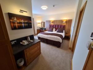 利物浦皇家酒店的酒店客房设有一张大床和一张书桌。