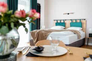 绿山城Apart House, Tylna 20的一间卧室配有一张床和一张桌子,上面有盘子