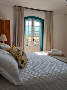 蒂拉登特斯Pousada Candelabro的一间卧室设有一张大床和一个窗户。