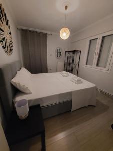 雅典Blue Flag Glyfada Center的卧室配有一张白色的大床和一张桌子