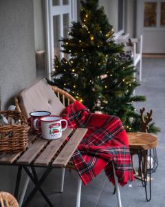泽拜盖尼Bonne Vie Cottage - Zebegény的圣诞树和一张桌子,桌子上放着杯子和毯子