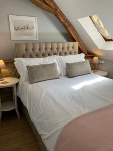 Corgnac-sur-lʼIsleCARIAD LA REBEUSE的卧室配有一张带两个枕头的大白色床