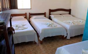 奥利文萨Pousada Ilha do Desejo的带3张白色床单的床的房间