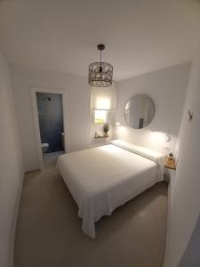 马拉加Frailes的白色的卧室配有一张白色的大床和镜子