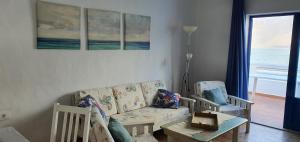 法马拉Seaview Risco de Famara 1的带沙发和椅子的客厅以及窗户。