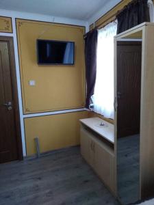 科普里夫什迪察Тороманова къща的一间黄色墙壁上配有电视的房间