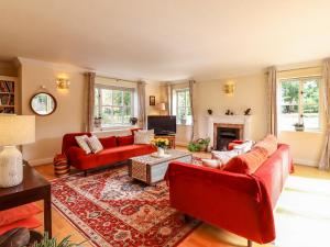 艾尔斯伯里Yew Tree Farm的客厅设有红色的沙发和壁炉