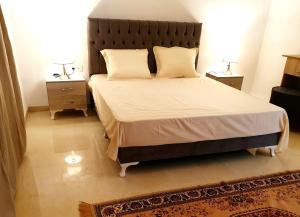 突尼斯Maison plain-pied avec piscine chauffée的一间卧室配有一张带2个床头柜的大床