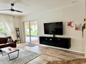 布雷登顿Sandy Oasis 5 bedroom with Pool Sarasota Bradenton的客厅设有壁挂式平面电视。