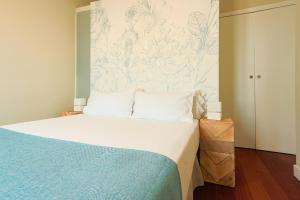 马拉加Madeinterranea Apartments的一间卧室配有一张蓝色和白色墙壁的床