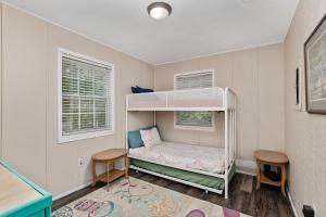 Family Forest Retreat, Paradise at Point Pleasant!的儿童卧室配有一张双层床和两把椅子