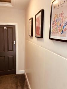 兰卡斯特'Bloomfield' at stayBOOM的墙上有三幅画的走廊和一扇黑色的门