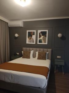 蓬德利马Hotel Rural Solar das Arcadas的卧室配有一张大床,墙上挂有两张照片