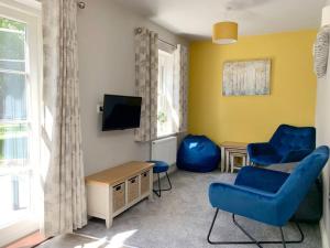 Park View Annexe的客厅配有2把蓝色椅子和电视