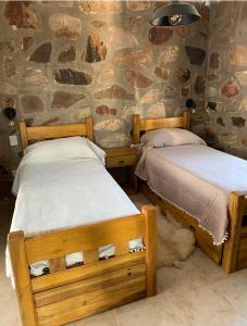 圣拉斐尔Casa Pueblo Benegas的石墙客房的两张床