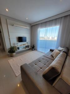 阿奎拉兹Casa Flórida的带沙发和大窗户的客厅