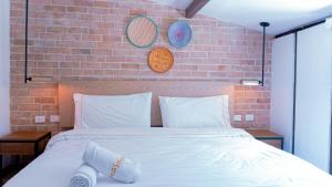 波哥大Masaya Bogotá的卧室配有白色的砖墙床