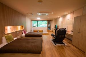 小樽Otaru Asari Classe Hotel的一间带两张床、一张沙发和一间厨房的房间