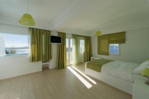 费拉特克斯别墅酒店的一间卧室设有一张床和一个大窗户
