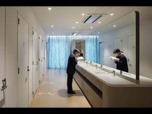 东京9h nine hours Ningyocho的男人站在浴室水槽前