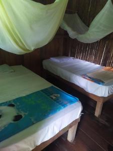 Santa RosaShintuyahotsprings的帐篷内的两张床,上面有一本书