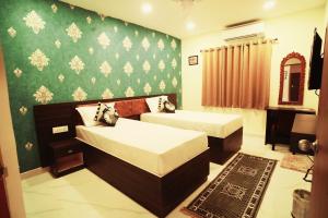 瓦拉纳西Anand Kanan的一间卧室设有两张床和绿色的墙壁