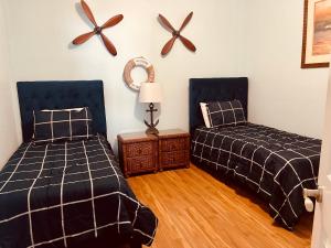 圣徒皮特海滩Two Bedroom Condo With Views Of The Beach & Gulf的一间卧室配有两张床、一张桌子和风扇。