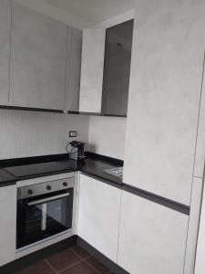 米兰Milano Santa Giulia Business Apartment - Olimpiadi 26的厨房配有白色橱柜和炉灶。