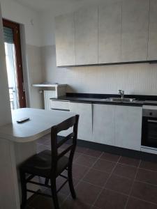米兰Milano Santa Giulia Business Apartment - Olimpiadi 26的厨房配有桌子、椅子和水槽