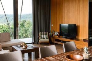 慕斯Atta Lakeside Resort Suite - SHA Plus Certified的客厅配有电视和桌椅