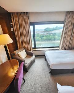 首尔Niagara Hotel的酒店客房设有床、桌子和窗户。