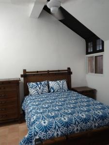 苏莎亚Sosua Apartment 4-Bedrooms的一间卧室配有一张带蓝色和白色棉被的床