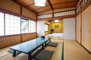 高冈市大佛日式旅馆的客房设有桌子、床和窗户。