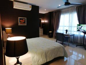 功孟海滩Klong Muang Beach Apartment的一间卧室配有一张床、一张书桌和一个窗户。