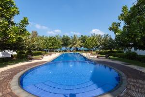 尼拉瓦利Oceanfront Condominiums - Nilaveli的公园里的一个游泳池,有长椅和树木