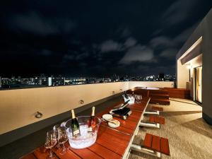 那霸Rakuten STAY Naha-Miebashi Suite Room的屋顶上配有带酒杯的长桌