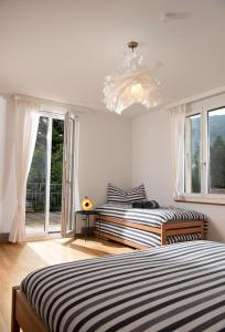因特拉肯Boutique Villa J87的一间卧室配有两张床和吊灯。