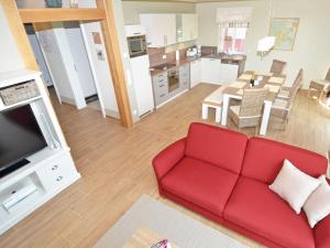 奥特里德维茨Haus Mönchgut - Haushälfte 2 "Findling"的一间带红色沙发的客厅和一间厨房