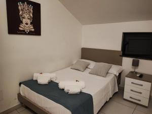 卡塔尼亚mungiBEDdu Apartment的一间卧室配有两张床和一台平面电视