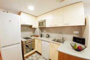赫罗纳Little Home Girona的小厨房配有白色橱柜和水槽