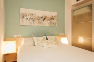 赫罗纳Little Home Girona的卧室配有白色的床和2个枕头